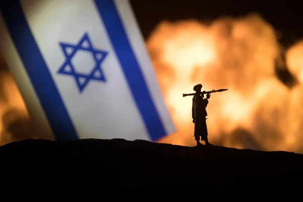 以色列小国旗在燃烧的黑暗背景 战争危机和国家间政治冲突的概念 军事战斗的轮廓与以色列国旗相对照 有选择的重点 — 图库照片