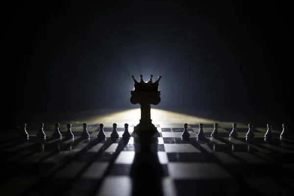 Peças de xadrez com rei na posição de liderança, colocadas na mesa