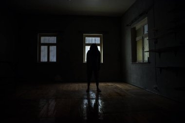 Geceleri penceresi olan terk edilmiş ürkütücü odada korku silueti. Korku sahnesi. Cadılar Bayramı konsepti.