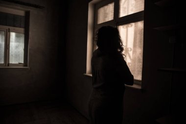 Geceleri penceresi olan terk edilmiş ürkütücü odada korku silueti. Korku sahnesi. Cadılar Bayramı konsepti.