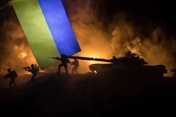 ウクライナの概念におけるロシアの戦争 ウクライナの国旗に対する武装した兵士のシルエットは都市を焼き尽くした 創造的なアートワーク装飾 夜の戦闘シーン 選択的焦点 — ストック写真
