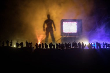 TV konseptinde sahte haberler. Kalabalığın siluetleri dev televizyon kutusuna bakıyor. Yaratıcı sanat dekorasyonu. Seçici odak