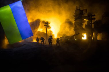 Silüet asker, küçük çocuğu ateşten omuzunda taşıyor. Rus savaşı Ukrayna konseptinde. Yanmış şehirden küçük bir çocukla taşınan adam savaşta yok oldu. Seçici odak