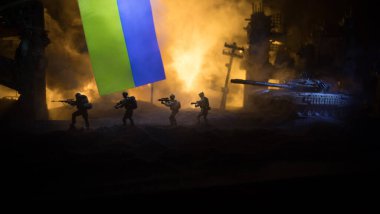 Rus savaşı Ukrayna konseptinde. Ukrayna bayrağına karşı silahlı askerlerin silueti ve yanmış şehir. Yaratıcı sanat dekorasyonu. Gece dövüşü sahnesi. Seçici odak