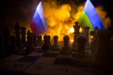 War between Russia and Ukraine, conceptual image of war using chess board, soldiers and national flags on the background of explosion. Ukrainian and Russian crisis. Selective focus
