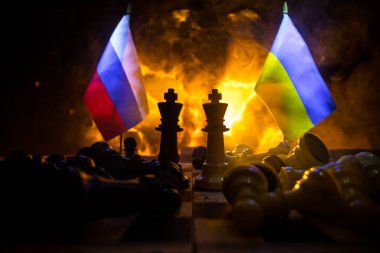 Rusya ve Ukrayna arasındaki savaş, satranç tahtası, askerler ve patlamanın arka planındaki ulusal bayrakları kullanarak savaşın kavramsal görüntüsü. Ukrayna ve Rusya krizi. Seçici odak