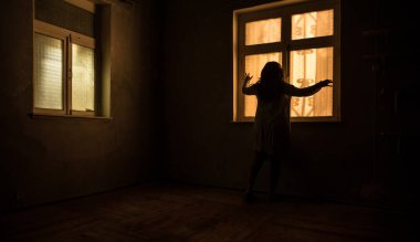 Geceleri penceresi olan terk edilmiş ürkütücü odada korku silueti. Korku sahnesi. Cadılar Bayramı konsepti.