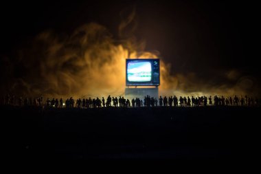 TV konseptinde sahte haberler. Kalabalığın siluetleri dev televizyon kutusuna bakıyor. Yaratıcı sanat dekorasyonu. Seçici odak