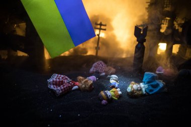 Savaşta ölen çocukların ölümü. Rus savaşı Ukrayna konseptinde. Küçük bebeğin yaratıcı sanat eserleri yanmış bir şehirde yatıyor. Seçici odak