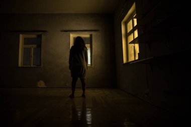 Geceleri penceresi olan terk edilmiş ürkütücü odada korku silueti. Korku sahnesi. Cadılar Bayramı konsepti.