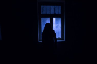 Geceleri penceresi olan terk edilmiş ürkütücü odada korku silueti. Korku sahnesi. Cadılar Bayramı konsepti.
