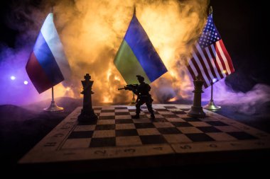 War between Russia and Ukraine, conceptual image of war using chess board, soldiers and national flags on the background of explosion. Ukrainian and Russian crisis. Selective focus