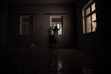Geceleri penceresi olan terk edilmiş ürkütücü odada korku silueti. Korku sahnesi. Cadılar Bayramı konsepti.