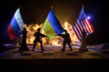 War between Russia and Ukraine, conceptual image of war using chess board, soldiers and national flags on the background of explosion. Ukrainian and Russian crisis. Selective focus