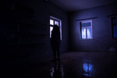 Geceleri penceresi olan terk edilmiş ürkütücü odada korku silueti. Korku sahnesi. Cadılar Bayramı konsepti.