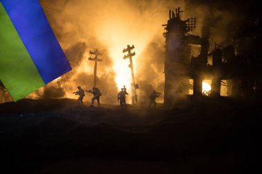 Silüet asker, küçük çocuğu ateşten omuzunda taşıyor. Rus savaşı Ukrayna konseptinde. Yanmış şehirden küçük bir çocukla taşınan adam savaşta yok oldu. Seçici odak