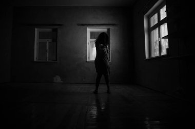 Geceleri penceresi olan terk edilmiş ürkütücü odada korku silueti. Korku sahnesi. Cadılar Bayramı konsepti.