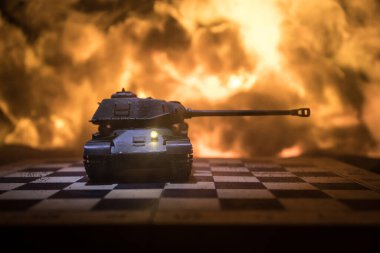 Rusya ve Ukrayna arasındaki savaş, patlamanın karanlık arka planında satranç tahtası ve tank kullanarak savaşın kavramsal görüntüsü. Ukrayna ve Rusya krizleri, siyasi çatışmalar. Seçici odak