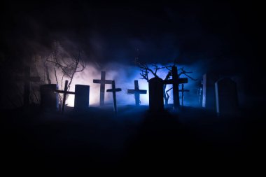 Zombilerin mezarlıktaki ölü ağaç, ay, kilise ve sisli ürkütücü bulutlu gökyüzü, Korku Cadılar Bayramı konsepti. Seçici odak