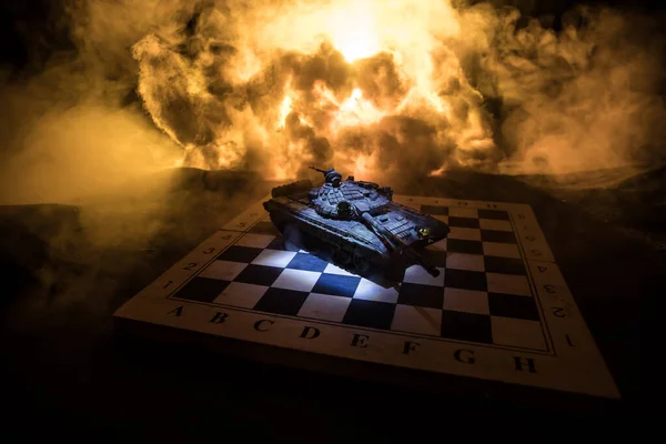 War between Russia and Ukraine, conceptual image of war using chess board and tank on a dark background of explosion. Ukrainian and Russian crisis, political conflict. Selective focus