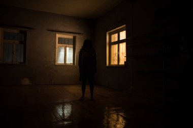 Geceleri penceresi olan terk edilmiş ürkütücü odada korku silueti. Korku sahnesi. Cadılar Bayramı konsepti.