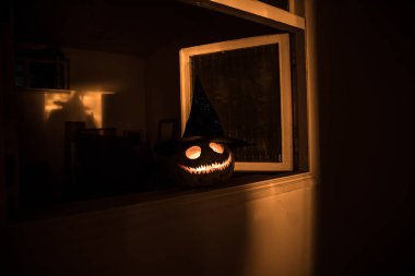 Geceleri mistik evdeki korkunç Cadılar Bayramı balkabağı ya da penceredeki cadılar bayramı balkabağı ve korku silueti. Seçici odak