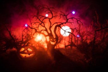 Ürkütücü karanlık manzara, sisli bir gecede bataklıktaki ağaç siluetlerini gösteriyor. Ateşin içindeki gizemli orman ve dramatik bulutlu gece gökyüzü