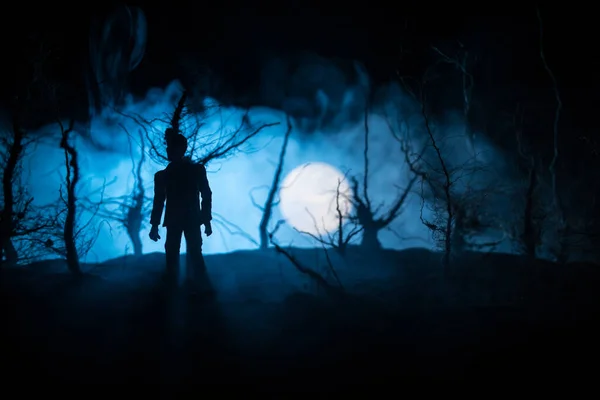 人のシルエットは暗い森の中に立っている ホラーハロウィンのコンセプト 夜の暗い不気味な森の中の奇妙なシルエット — ストック写真