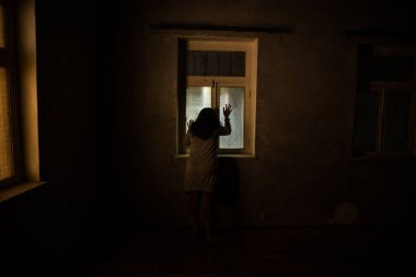 Geceleri penceresi olan terk edilmiş ürkütücü odada korku silueti. Korku sahnesi. Cadılar Bayramı konsepti.