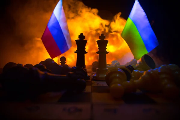 War between Russia and Ukraine, conceptual image of war using chess board, soldiers and national flags on the background of explosion. Ukrainian and Russian crisis. Selective focus
