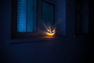 Geceleri mistik evin penceresinde korkunç Cadılar Bayramı balkabağı ya da pencereli terk edilmiş bir odada Cadılar Bayramı kabağı. Seçici odak