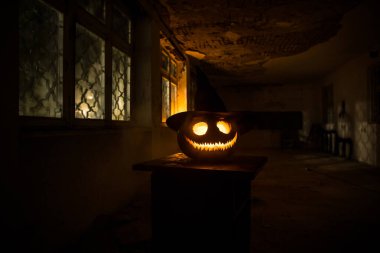 Geceleri mistik evin penceresinde korkunç Cadılar Bayramı balkabağı ya da pencereli terk edilmiş bir odada Cadılar Bayramı kabağı. Seçici odak