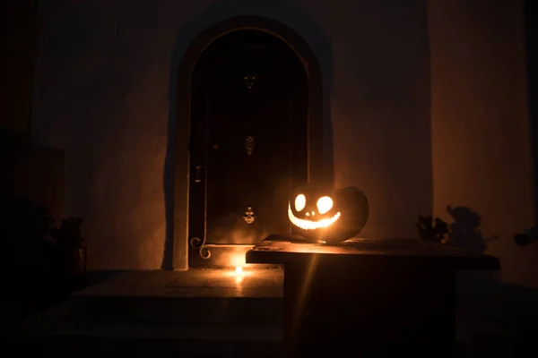 ハロウィンカボチャで飾られた家へのフロントドア 夜には急なドアの上にハロウィンカボチャ 選択的焦点 — ストック写真