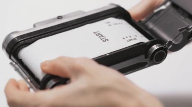 Film yükleniyor, Kullanıcı yeni yüklenmiş orta formatta film kamerası fotoğraf çekmeye hazır.