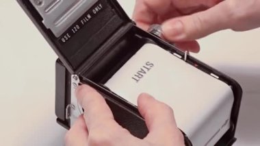Film yükleniyor, Kullanıcı yeni yüklenmiş orta formatta film kamerası fotoğraf çekmeye hazır.