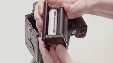 Film yükleniyor, Kullanıcı yeni yüklenmiş orta formatta film kamerası fotoğraf çekmeye hazır.