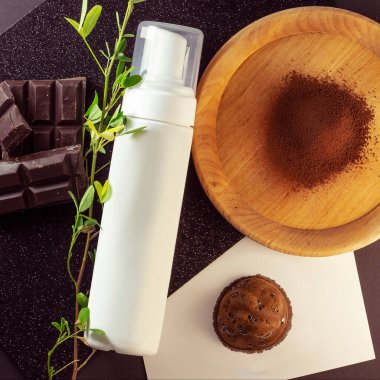 Kozmetik temiz şişe. Üstünde etiket olmayan tüpler. Mockup krema ürünleri. Kahverengi köpüklü bronzlaştırıcı ve bronzlaştırıcı beyaz kağıt üzerinde kakao tozu ve siyah çikolata. 