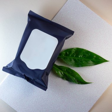 Kozmetik temizlik mendilleri. Üzerinde etiket olmayan siyah paket. Peçete için hazırlan. Mendilleri temizliyorum. Makyaj temizleyici. Yeşil yaprak güzel bir kompozisyon için dekorasyon gibi..