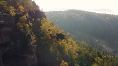 Açık mavi gökyüzünün altındaki doğal kayalar ağaçlar ve vadilerle çevrili manzaralarla çevrili..