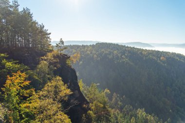 Açık mavi gökyüzünün altındaki doğal kayalar ağaçlar ve vadilerle çevrili manzaralarla çevrili..