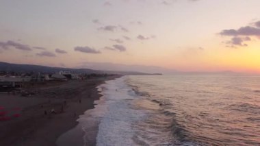 Bir İHA gün doğumunda Ege Denizi sahilinde adanın üzerinde uçar..