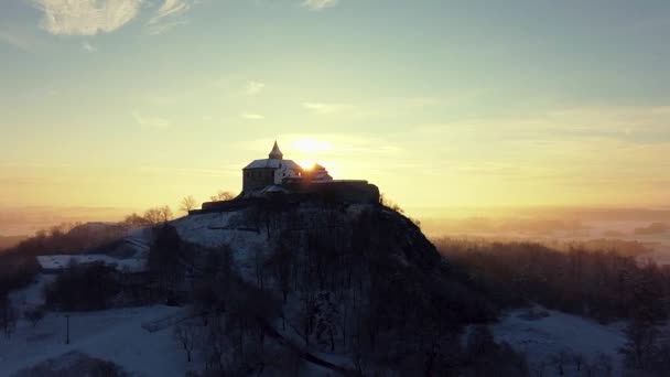 Antena, wczesny poranek widok na zamek stojący na wzgórzu nad mgłą o wschodzie słońca, światło przez poranne promienie słońca. — Wideo stockowe