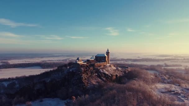 Повітряний, ранковий вид замку стоїть на пагорбі над туманом на світанку, світло за ранковими променями сонця.. — стокове відео