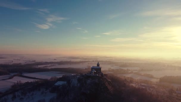 Antena, wczesny poranek widok na zamek stojący na wzgórzu nad mgłą o wschodzie słońca, światło przez poranne promienie słońca. — Wideo stockowe