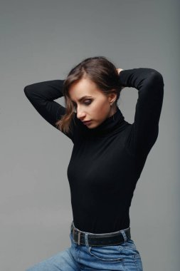 Stüdyoda makyaj yapmış güzel, çekici bir moda kadını. Gri arka planda güzel bir kadının şehvetli portresi.