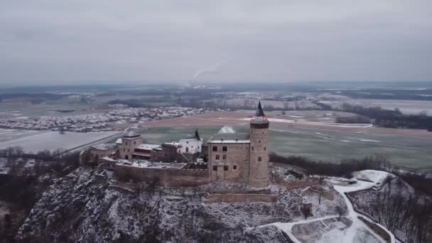 Aerial, early morning view of the Castle standing on the hill above fog at sunrise, light by morning sun rays. — Stock Video