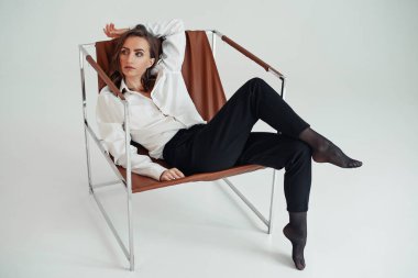 Kendine güvenen, siyah pantolonlu, yüksek bel ve beyaz gömlekli güzel bir kadın. İş kadını kavramı.