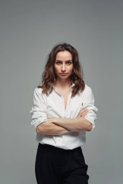 Kendine güvenen, siyah pantolonlu, yüksek bel ve beyaz gömlekli güzel bir kadın. İş kadını kavramı.