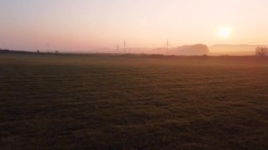 Tren sonbahar gündoğumunda kırsal kırsalda yol alır. Tren doğadaki güzel sonbahar tarlası boyunca yol alır. Harika güneş ışığı.