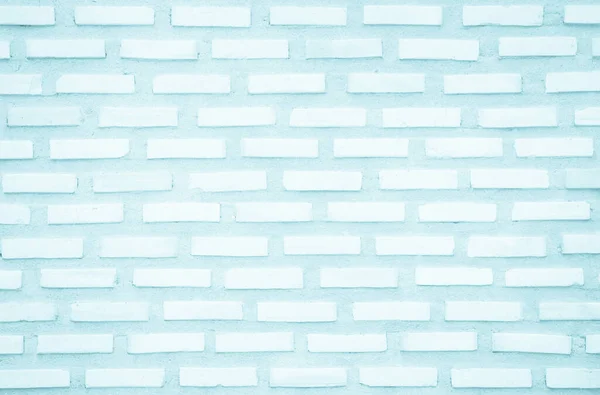 Brick wall painted with pale blue paint pastel calm tone texture background. Brickwork and stonework flooring interior rock old pattern clean concrete grid uneven bricks design stack backdrop.